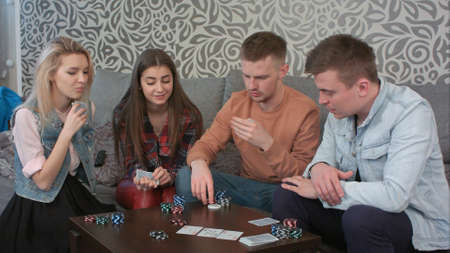 Teen friends playing cards at homeの写真素材