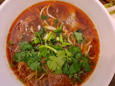 Thai spicy noodle soup with pork and coriander.
