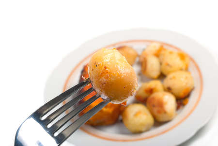 baked potatoes,roasted vegetables Close-up .fork with potatoesの写真素材