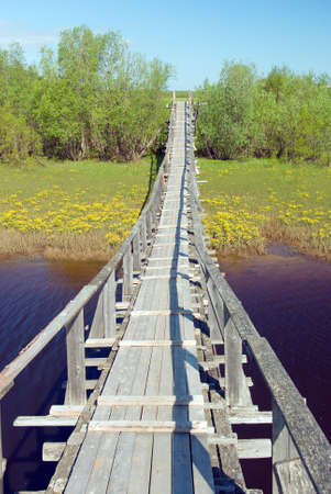 Suspension bridge over the river.Old Style Suspension Bridge -- crossing a mountain riverの写真素材