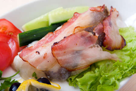 The halibut prepared with vegetables and bacon.close upの写真素材