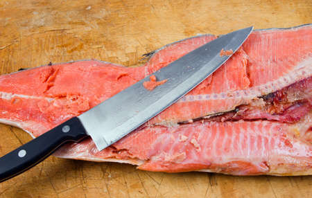 Cutting the salmon with a knife. fishの写真素材