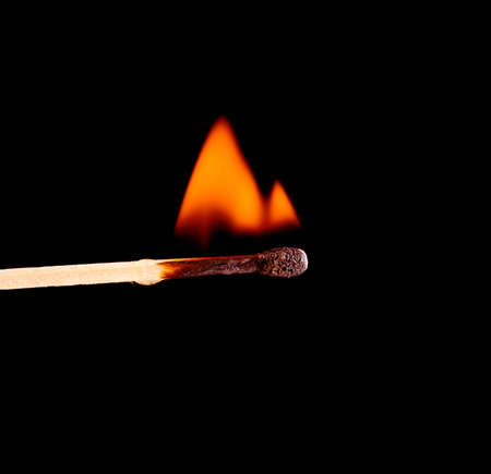 colorful flame with wooden matchstick, isolated on blackの写真素材
