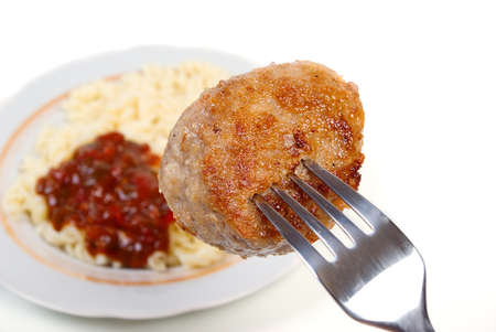 chop on fork.Pork chop.Paste  and tomato sauce on plateの写真素材