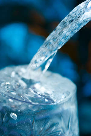 Macro of water poured into a glass of water with bubblesの写真素材