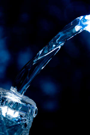 Macro of water poured into a glass of water with bubblesの写真素材