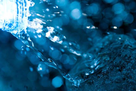 Macro of water poured into a glass of water with bubblesの写真素材