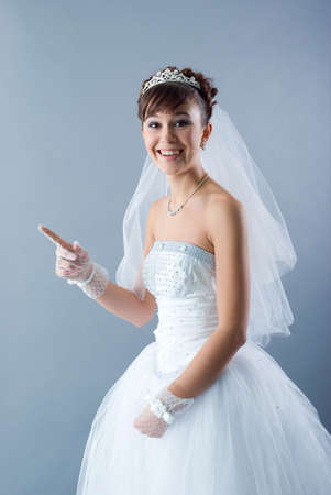 Beauty young bride dressed in elegance white wedding dress  gray studio background の写真素材