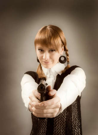 blonde holding a gun and aiming toward camera, focus on gun の写真素材