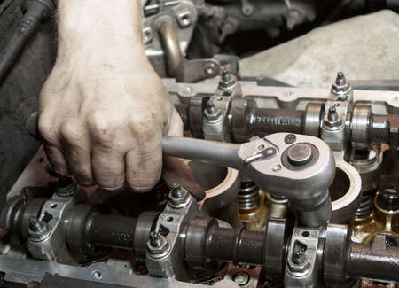Repair of the engine. A hand with the tool. Automobile service 