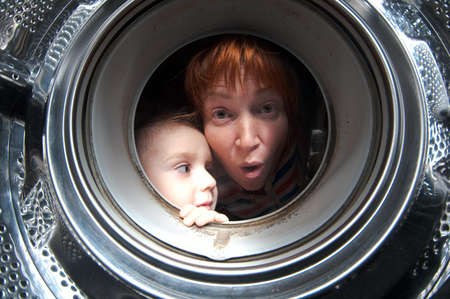 woman and boy peer into get old washer の写真素材