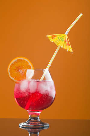 red coctail drink with ice cubs  on yellow background の写真素材