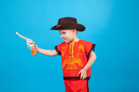 little boy wearing a cowboy hat a over blue backgroundの写真素材