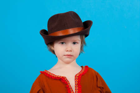 little girl wearing a cowboy hat a over blue backgroundの写真素材