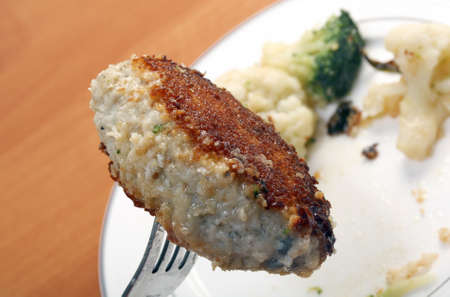Cutlets in a plate with vegetables.Close-up .fork with chopの写真素材