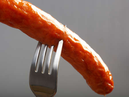Grilled hot dog on forkの写真素材