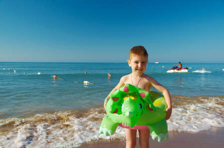 Little boy in the waves on the sea beachの写真素材