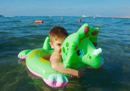 Little boy in the waves on the sea beachの写真素材