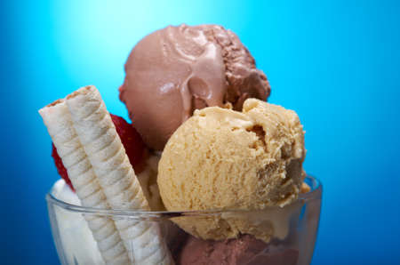 ice cream in with strawberries and chocolate. closeup .on blue background.