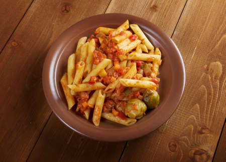 Italian Penne rigate pasta  with  vegetable  tomato sauce  on wooden tableの写真素材