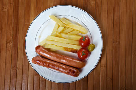 Sausages with french fries and vegetablesの写真素材