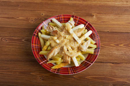 Poutine - common Canadian dish, originally from Quebec, made with french fries, topped with a light brown gravy-like sauce and cheese curdsの写真素材