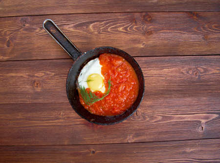 Matbucha and scrambled eggs cooked dish of tomatoes and roasted bell peppers  with garlic and chili pepper. popular across the Maghrebの写真素材