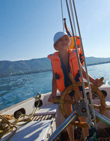Cute little boy at sail boat wheelの写真素材