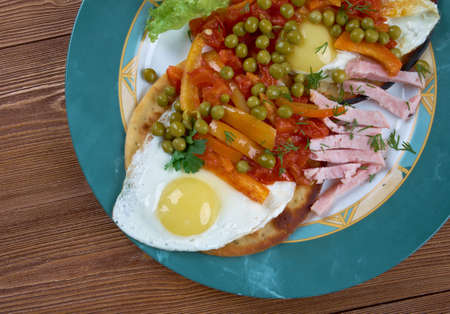 Huevos Motulenos -  breakfast food in the town of Motul (YucatÃ¡n)  dish is made with eggs on tortillas ,  ham, peas, plantains, and salsa picanteの写真素材