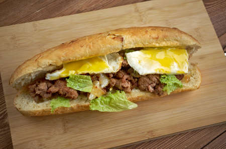 Cheesesteak - sandwich combining frizzled beef, onions, and cheese in a small loaf of bread