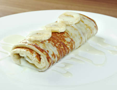 stuffed pancakes with sweet sauce and bananasの写真素材