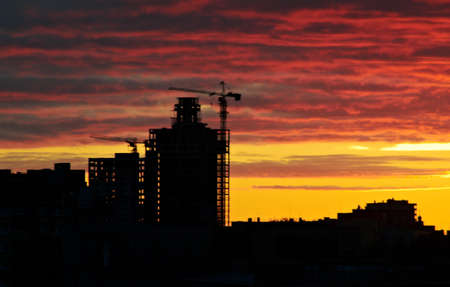 silhouette crane on building at sunsetの写真素材
