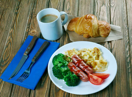 Country breakfast - scrambled eggs, sausages, vegetables, coffee and croissantの写真素材