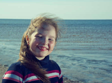Little girl on the background of the sandy seashore