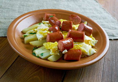 Huevos rotos con chistorra.scrambled eggs with sausage and potatoes. Mexican style.