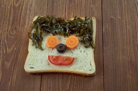 creative food concept  -  Funny sandwich for kids  man made of toast, sausage, vegetables,Sea kale