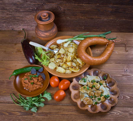 Russian summer dinner , food in assortment : Fried potatoes, smoked sausage, eggplant caviar, salted mushrooms.の写真素材