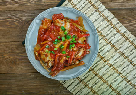 Roman-Style Chicken - simple braise of chicken with white wine, tomatoes, garlic and a colorful mix of roasted red, green and yellow bell peppersの写真素材