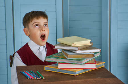 Little child stressed tired leaning on pile of books, vintage conceptの写真素材