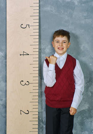 Schoolboy next to the measuring ruler, vintage conceptの写真素材