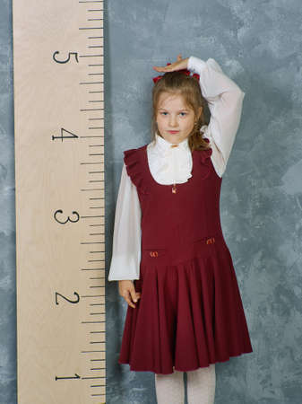 Schoolgirl next to the measuring ruler, vintage conceptの写真素材