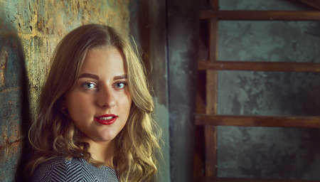 Cheerful good-looking young light-brown hair woman on dark grunge background