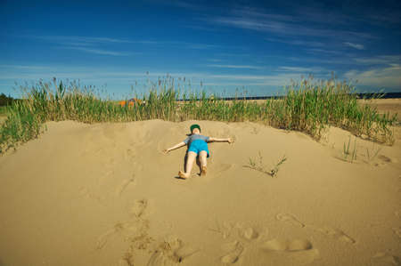 The boy rests on the sand dunes, the White Sea coastの写真素材