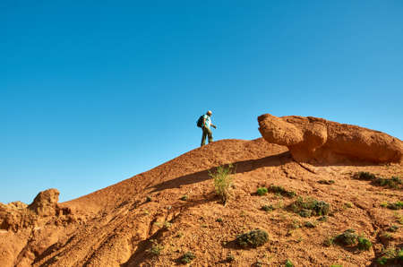 caucasian man with backpacks hiking to top of mountain Central Asiaの写真素材