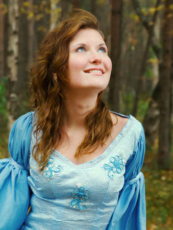 Very beautiful girl in medieval dress in autumn wood.の写真素材