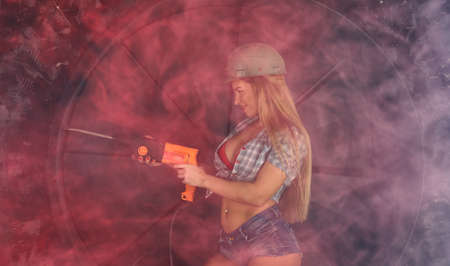 girl in construction clothes and protective equipment posing  on grunge backgroundの写真素材