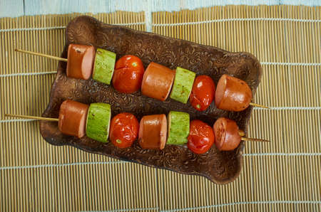 Sausage courgette kebabs, wooden sticks through the cherry tomatoes, peppers, courgettes and pieces of sausageの写真素材