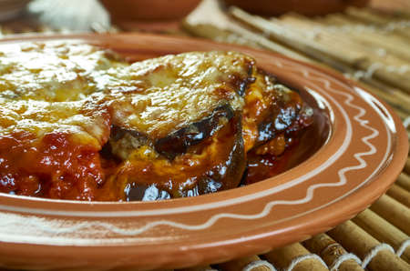 Parmigiana siciliana di melanzane - Italian dish Sicilia made with a shallow or deep-fried sliced eggplant filling, layered with cheese and tomato sauce, then baked