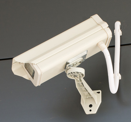 Soft focused picture of  white cctv camera or security system installed on the wall