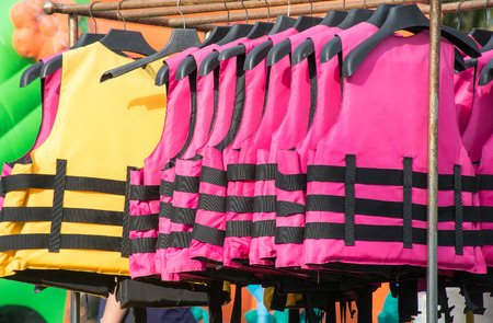 Soft focused picture of Multiple colour of Life jacket are hanging on Clotheslineの写真素材